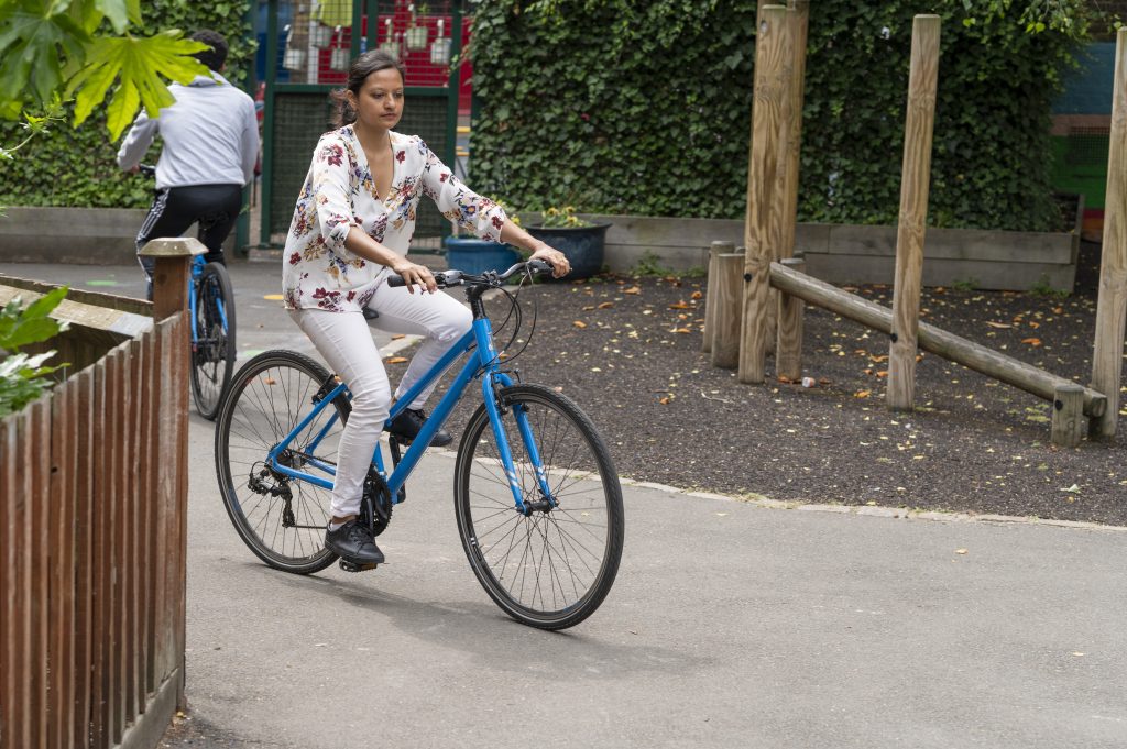 Woman riding blue bike.